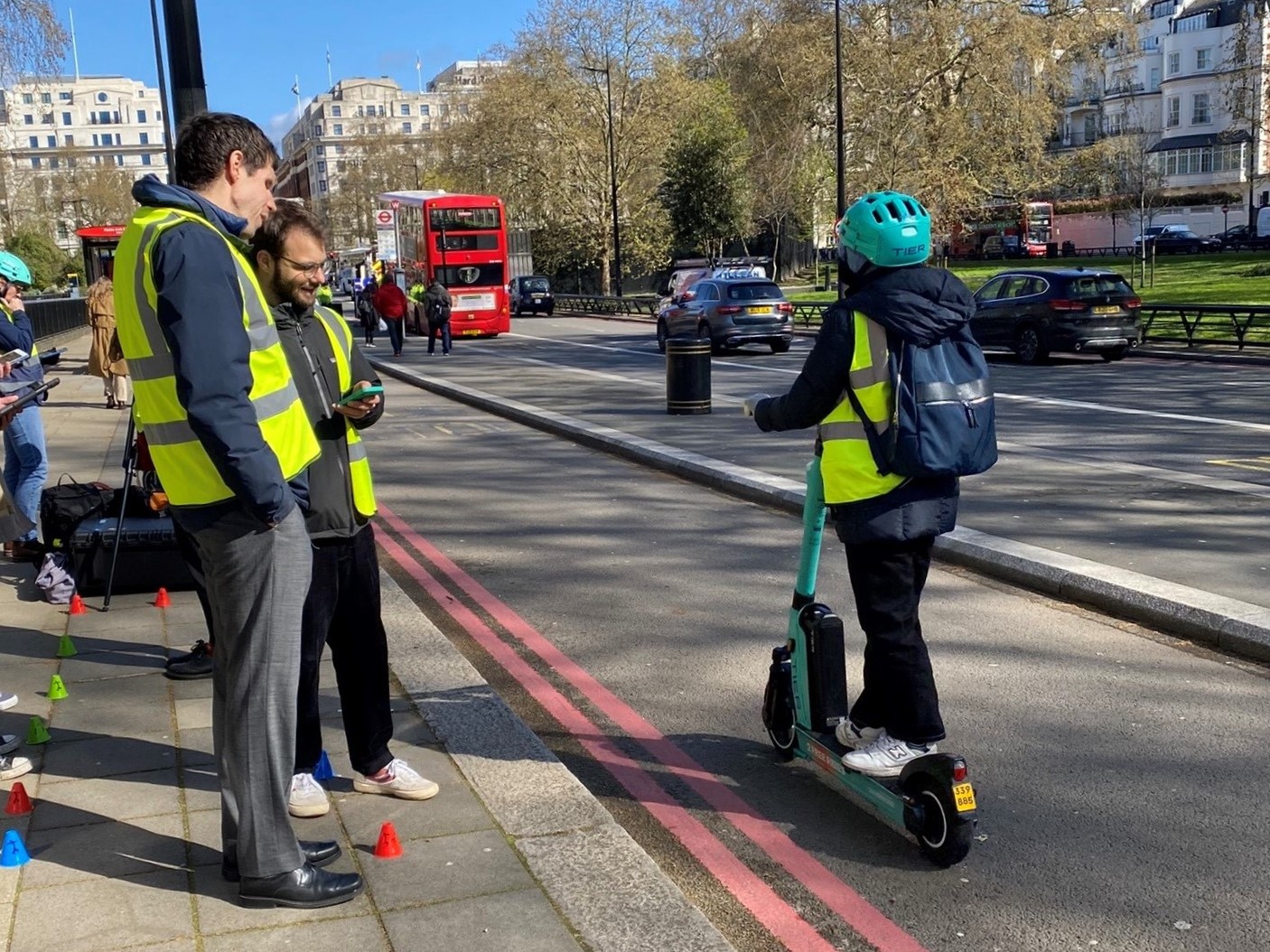 Andy Law, Campaigns Manager for Thomas Pocklington Trust, pictured with a member of the team from UCL Pearl by the edge of the road. They are listening for the AVA on a passing e-scooter.
