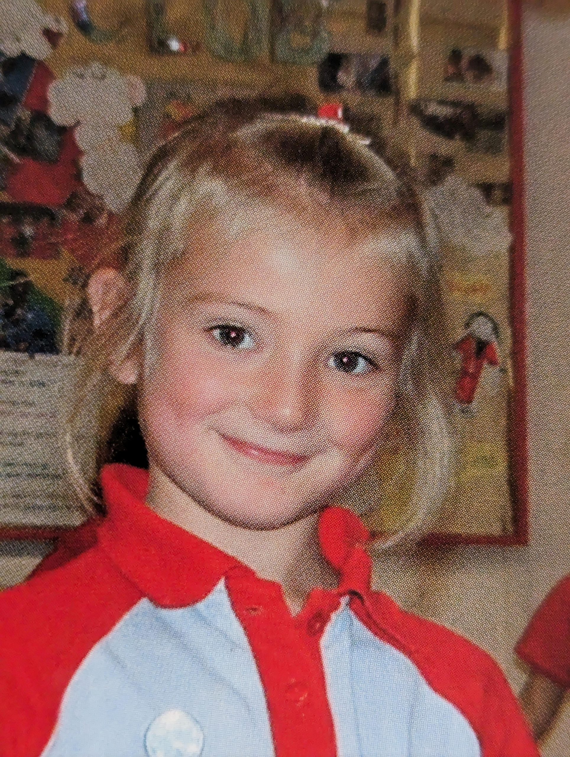 Belle Whitely, SLC coordinator for Yorkshire and Humberside. She is 8 years old in this picture and has blond hair, tied in a ponytail. She is wearing a red and white jumper, and smiling at the camera.
