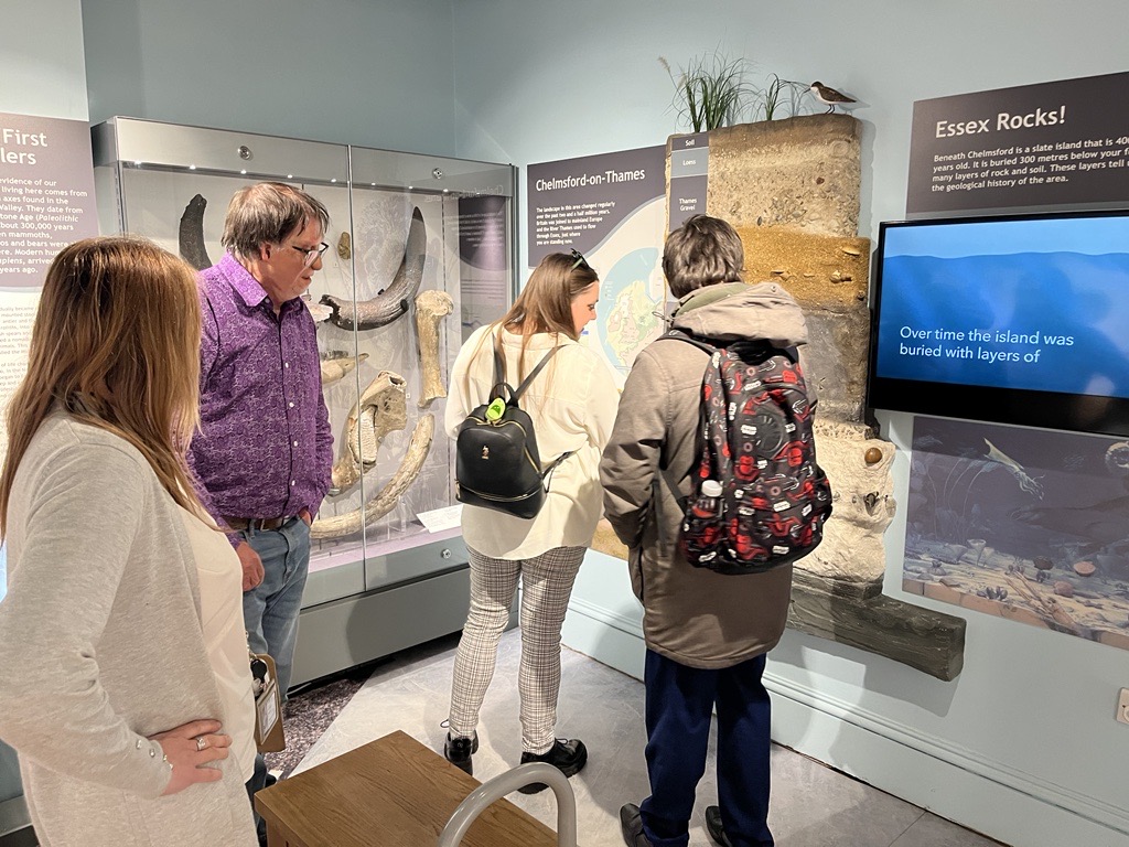 Samantha Leftwich, and SLC member Alex, looking at a display at Chelmsford Museum. Two staff members are stood behind them.