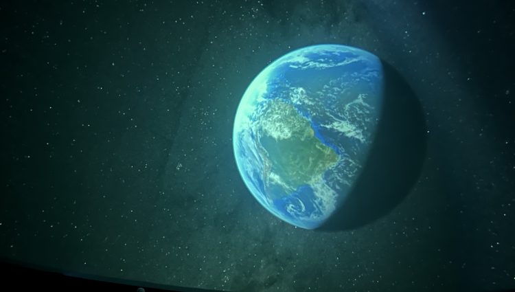 Planet Earth, shown from space, with darkened sky and stars.
