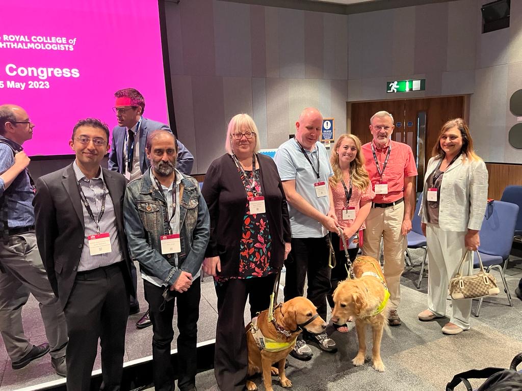 Chair of the Royal College of Ophthalmologists Training Group, Sunil Mamtora (left), stood facing camera with SLC members Paul and Clare (third and fourth from left). They are stood in a line with ophthalmologists and other patients at the congress event.