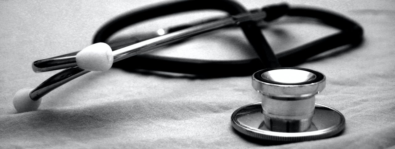 A close up photo of a stethoscope, sitting on a pale grey piece of fabric.