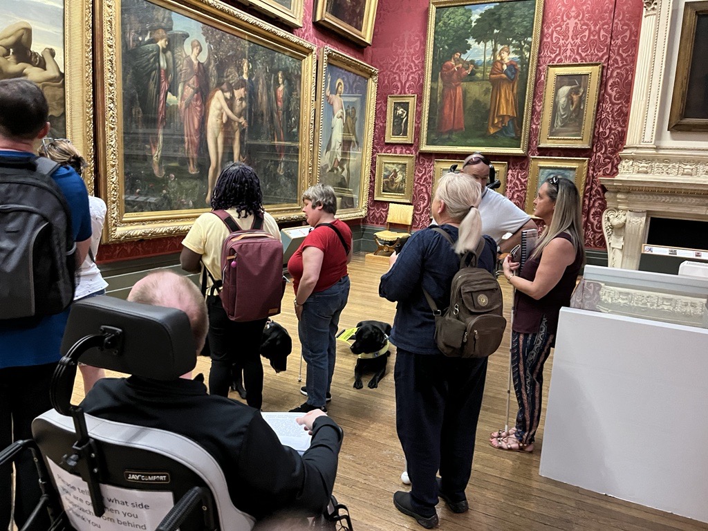 Members of Merseyside SLC at the Walker Art Gallery. The room is full of large artworks, in gold guilted frames. SLC members are looking towards a wall of art.