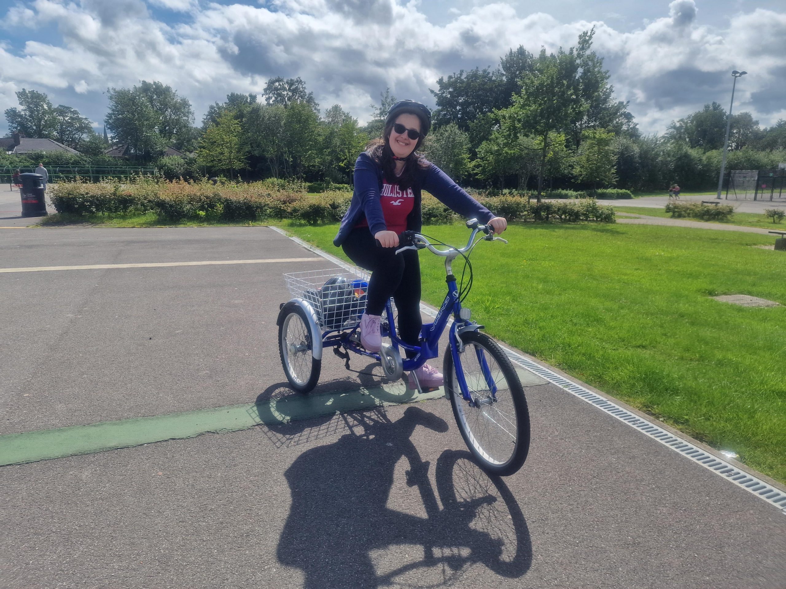 Emily, one of our attendees, is shown sitting outside on a tricycle.