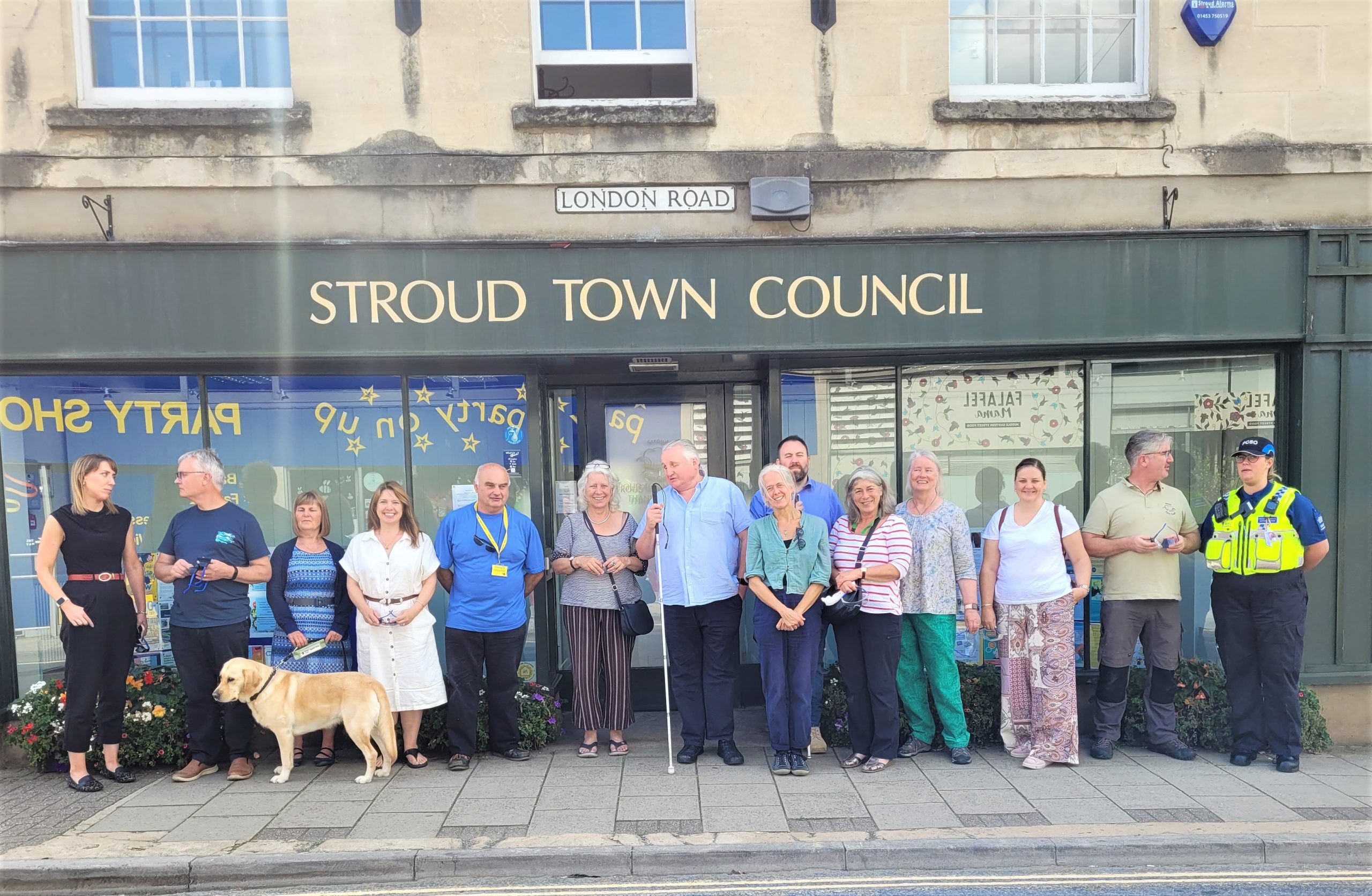 Members of Stroud District and Stroud Town Councils are stood with Gloucestershire SLC members outside Stroud Town Council. They are in a line, smiling at the camera.