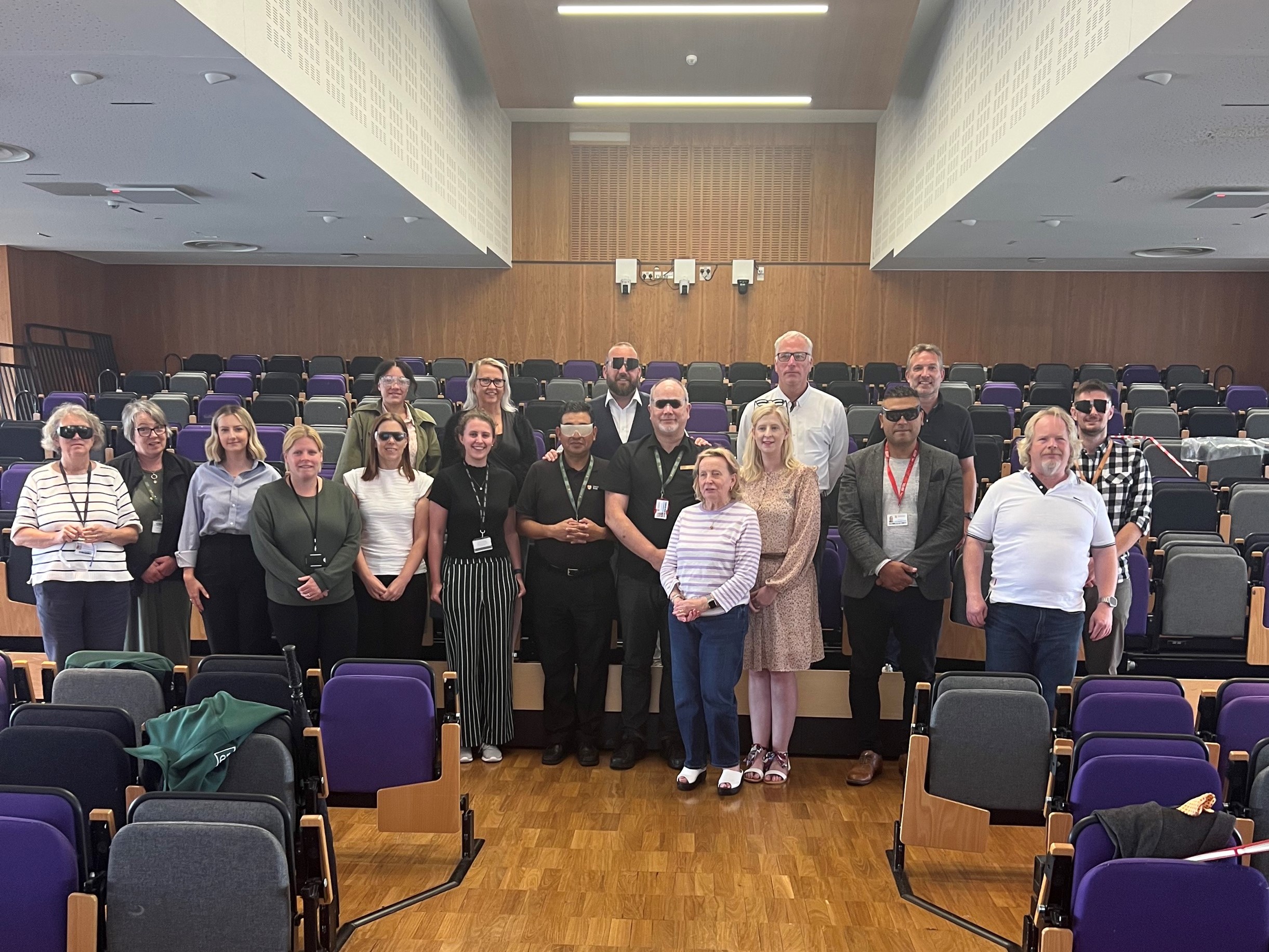 A group photo of West Midlands SLC members, Louise Connop, Martin Symcox, and University of Birmingham staff. They are all stood together , looking at the camera.