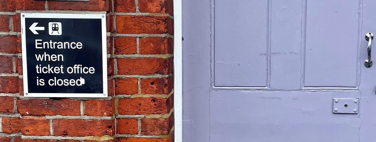 Image of a closed door at a ticket office. The image shows a sign to the left of the door which reads: 'Entrance when ticket office closed.'