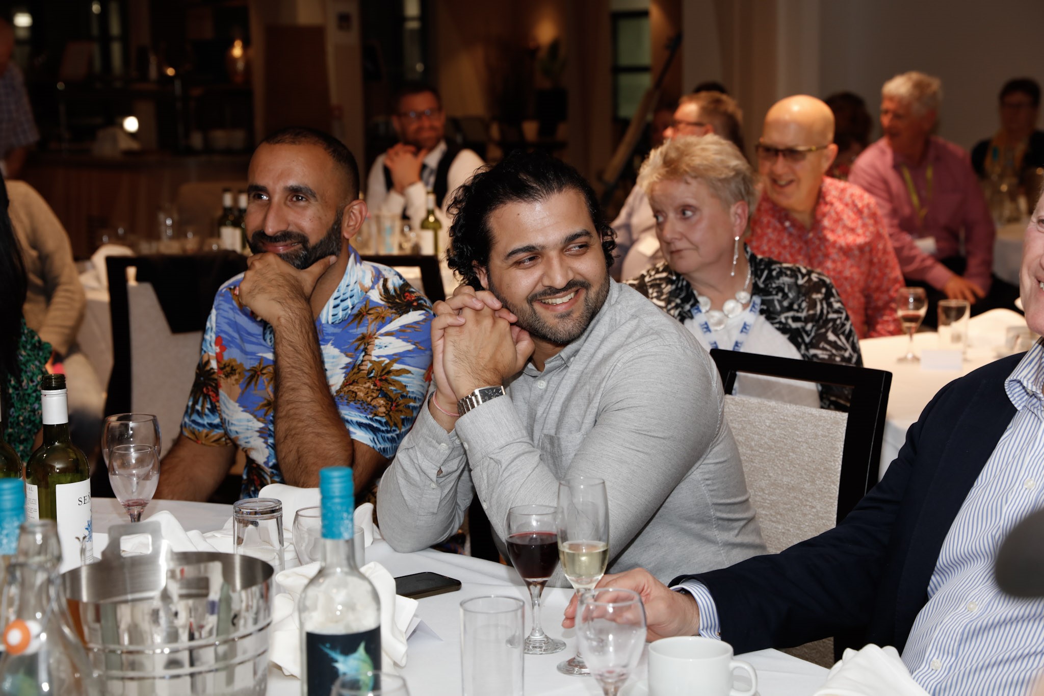 Davinder, London SLC member, pictured with his support worker Vinny, at the RPA awards. They are sitting at their dinner table, smiling.