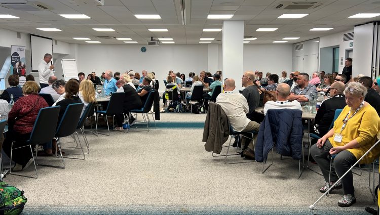 Delegates sitting around round tables in the main conference room at our 2023 SLC conference.