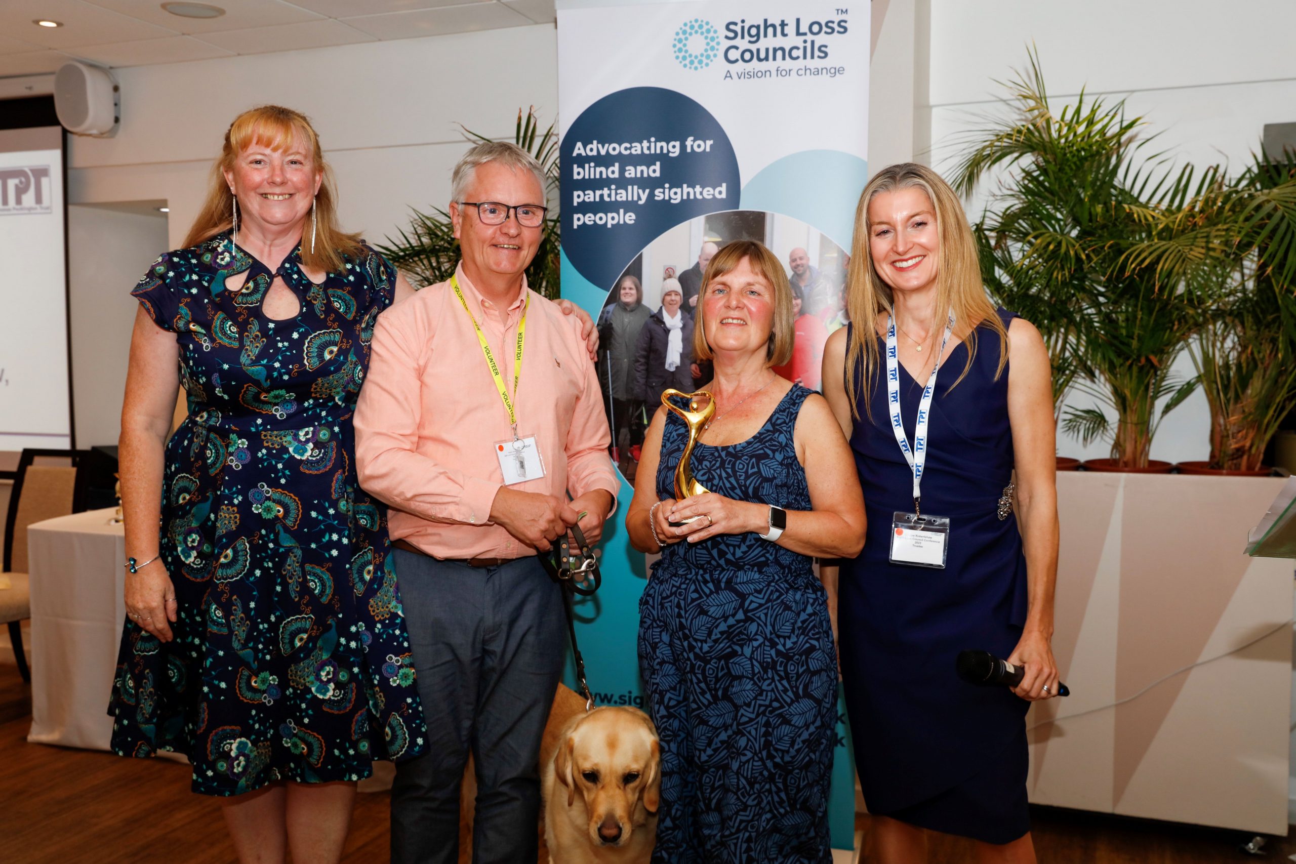 From left to right: Tricia Sail, Stuart & Julie Stephens Gloucestershire SLC, guide dog Heidi, and Louise Robertshaw, Trustee at TPT. Julie is holding her award for individual of the year.