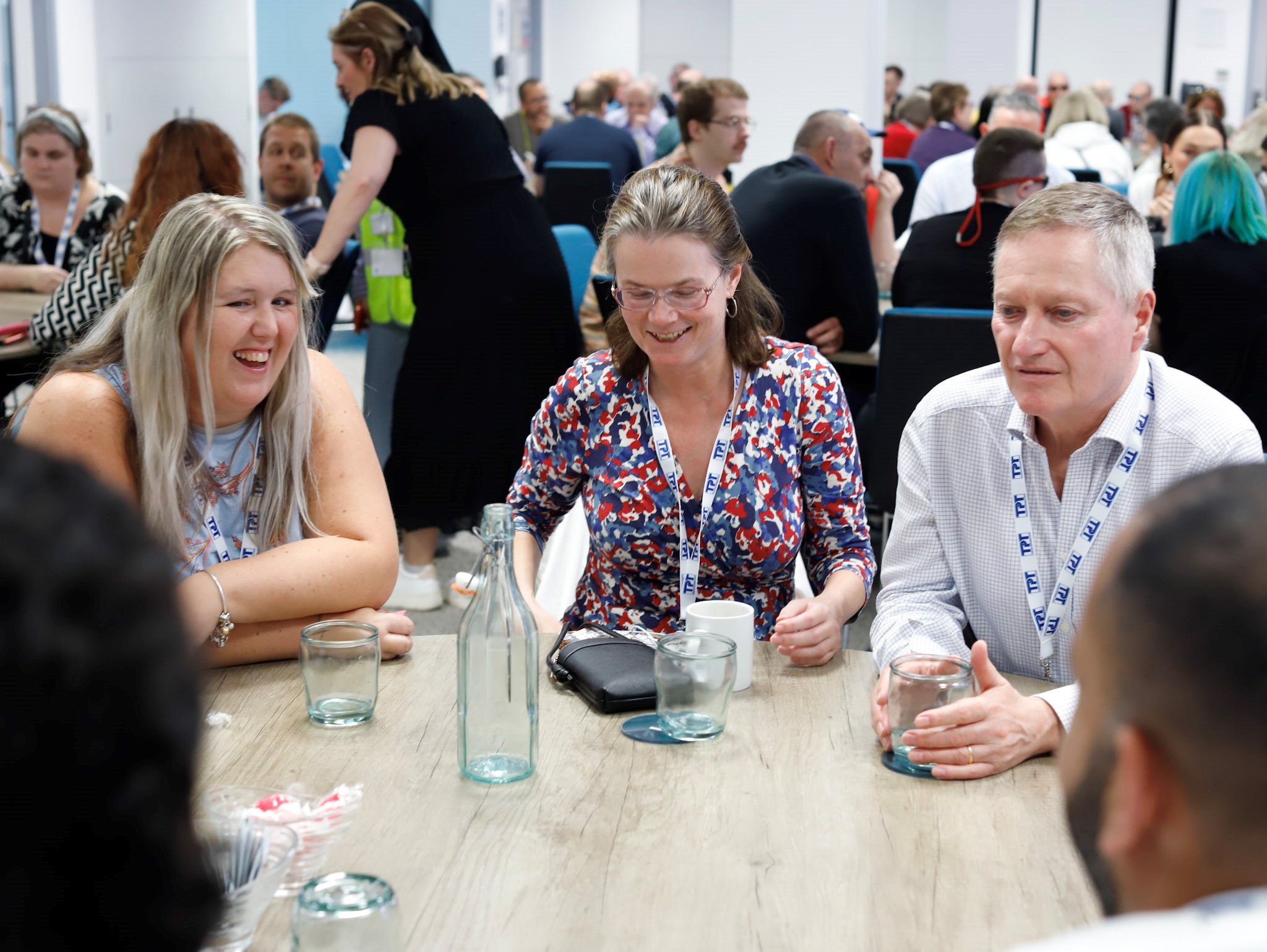 Leanne Best, Vicky Blencowe, and Harry Meade, from London Sight Loss Councils, seated at a round table laughing.