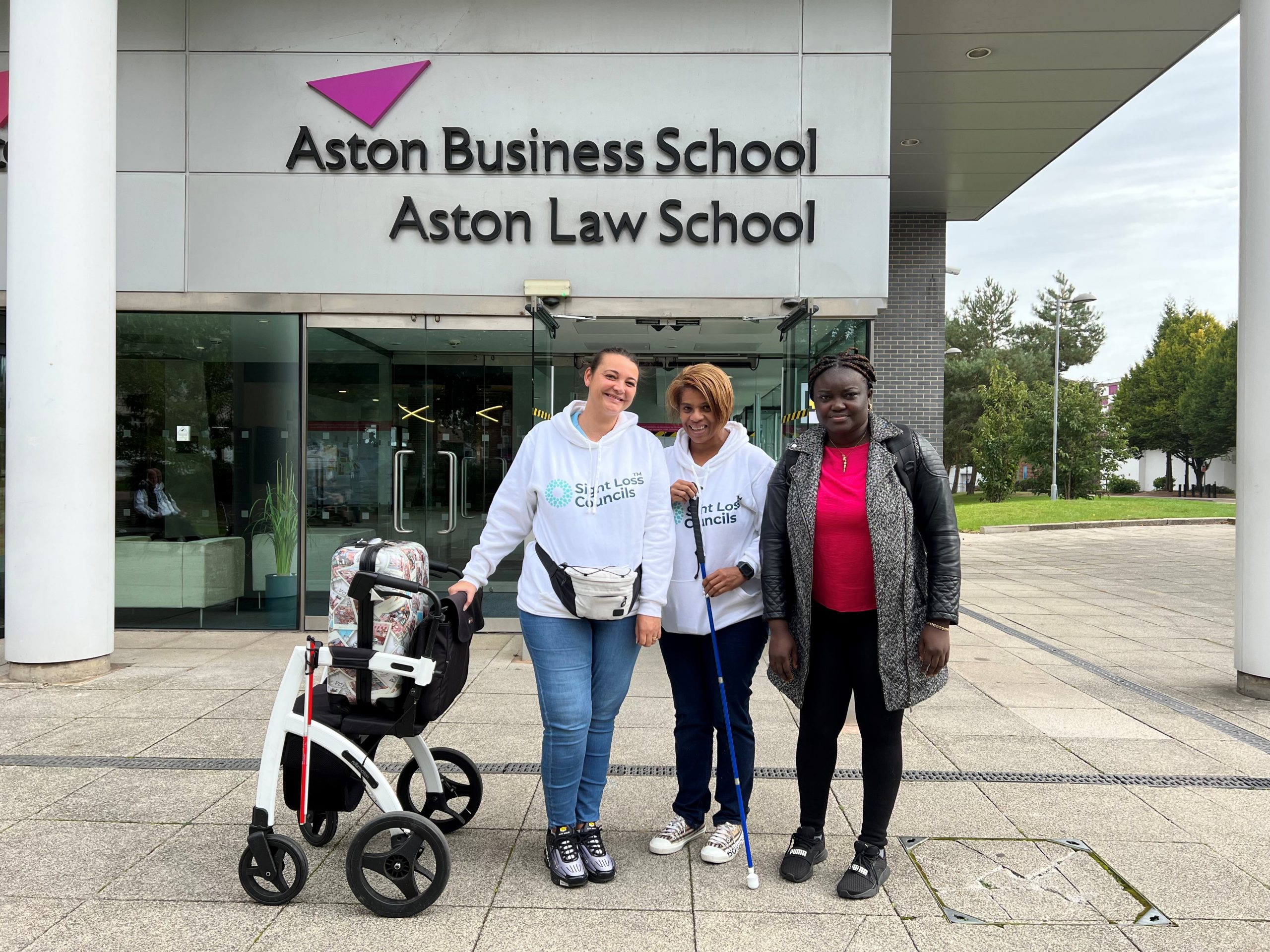 Nikki, Jennifer, and Lilian, South West London SLC members. They are stood outside Aston Conference centre upon arrival at the 2023 SLC Conference.