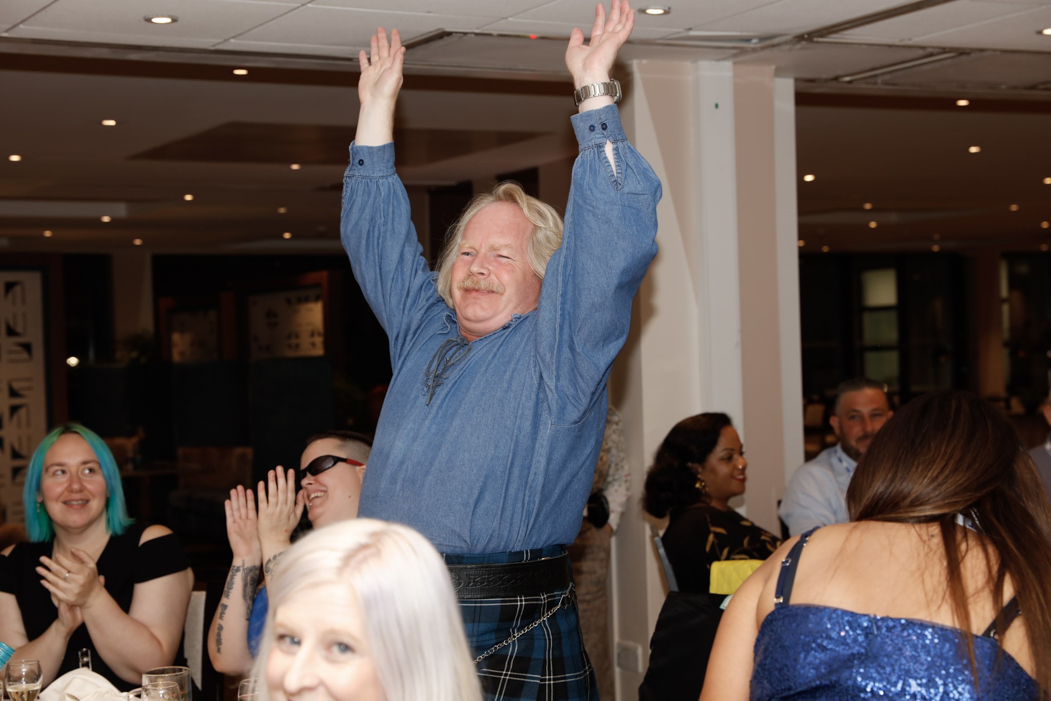 Steve Keith, Birmingham and Black Country SLC member, pictured standing up, with his hands in the air during the Rodney Powell Awards.