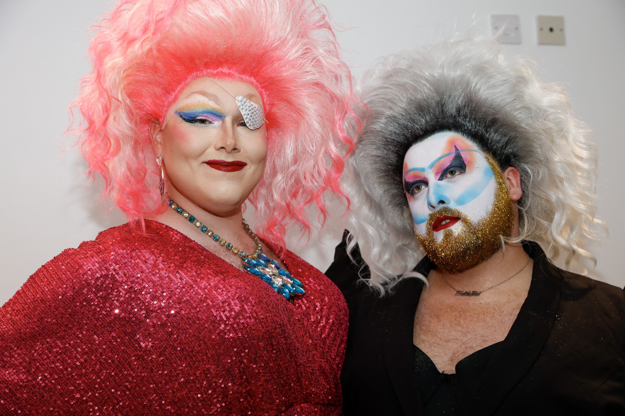 Venetia Blind and Mel Teasers, this year's entertainment. venetia is wearing a bright pink and white wig and red sequinned dress. Mel has a big, white wig, pink, white and blue make-up covering her face, and a gold glittery beard.