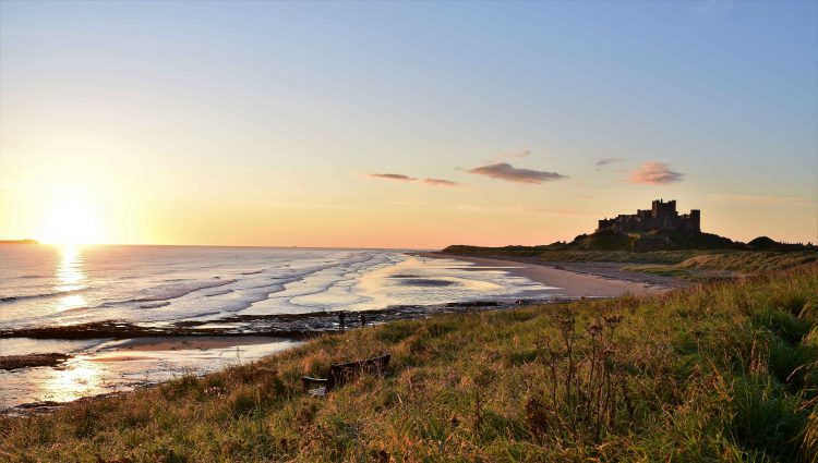 Photo of Bamburgh Castle, taken from the sand dunes on the beach in front of it.