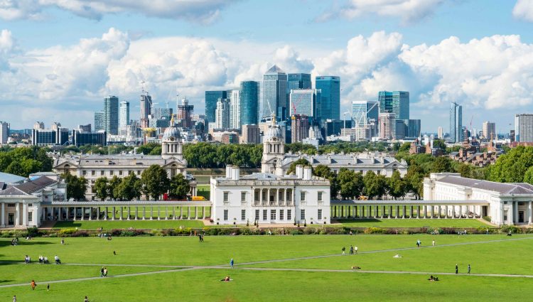 View from the top of the hill at Greenwich Observatory, looking down to the Maritime Museum. Several skyscrapers are shown in the distance at Canary Wharf and the City of London.