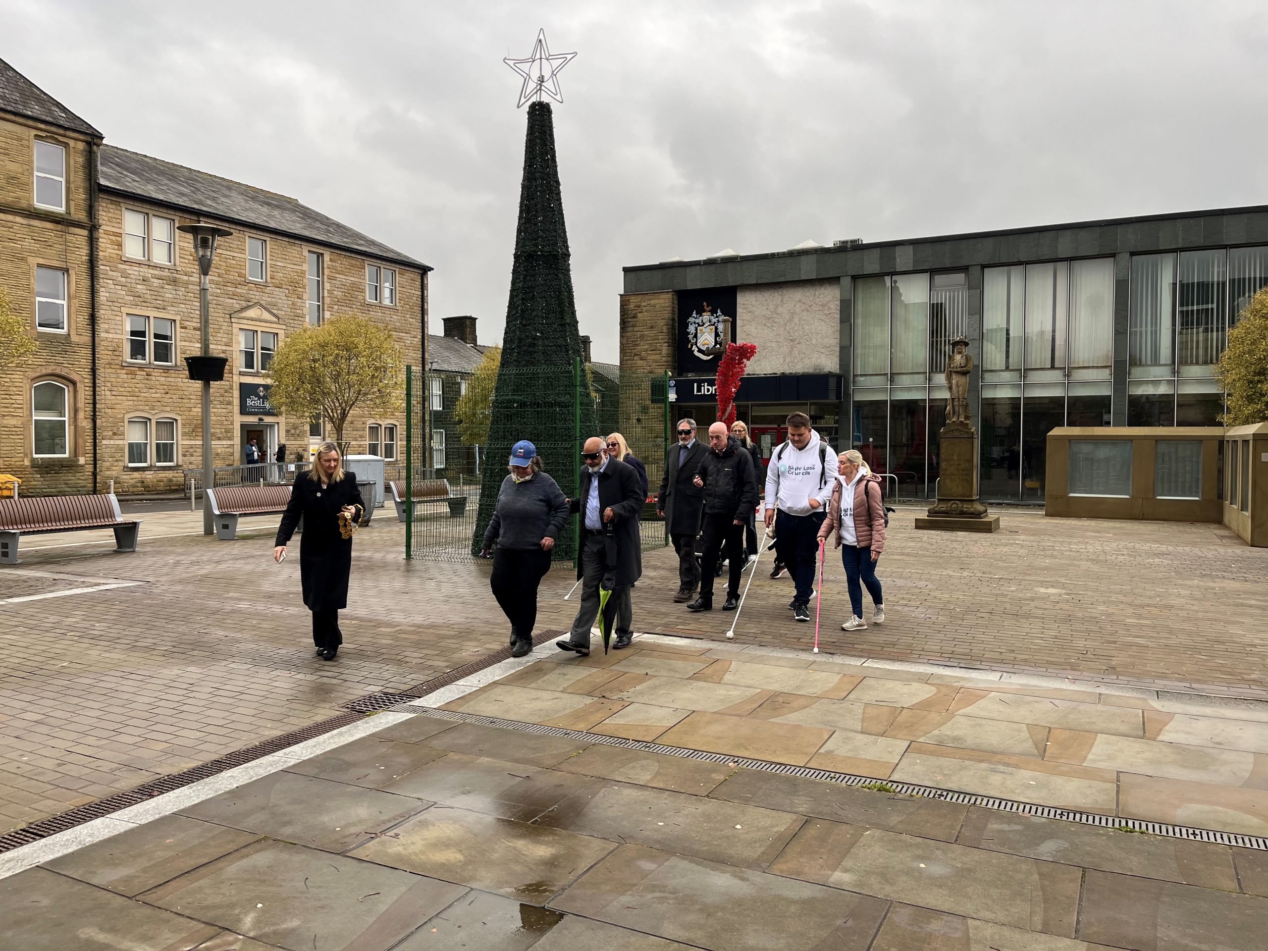 Officers and councillors from Pendle Borough Council starting off on the simulation spec walk from outside the library.