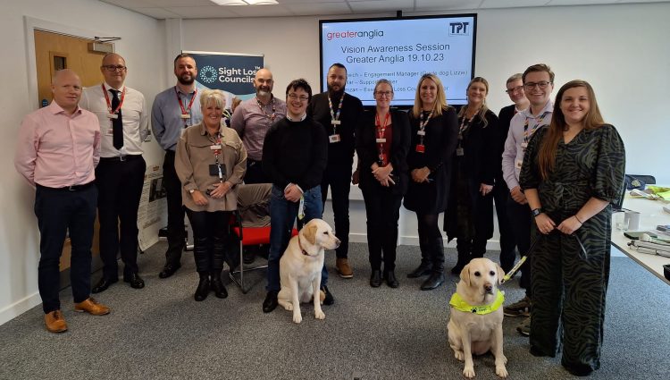 Staff from Greater Anglia's management team, stood with Samantha Leftwich, Engagement Manager for East England and Guide Dog Lizzie, and Essex SLC member, Alex Ramzan and his guide dog.