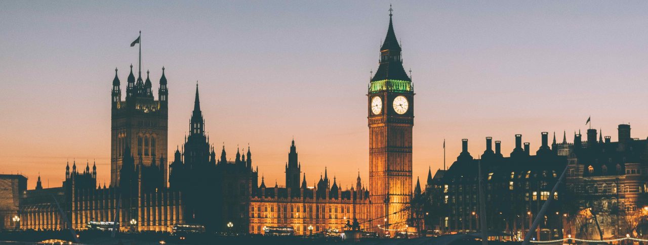 Westminster, Big Ben, and the Houses of Parliament at dusk from across the River Thames.