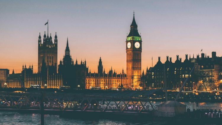 Westminster, Big Ben, and the Houses of Parliament at dusk from across the River Thames.