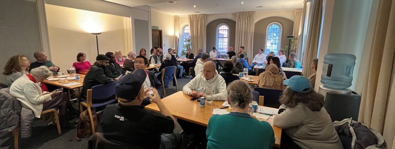 Attendees at London Sight Loss Councils' retail event. Image taken from the back of the room and shows several tables of attendees seated during the event.