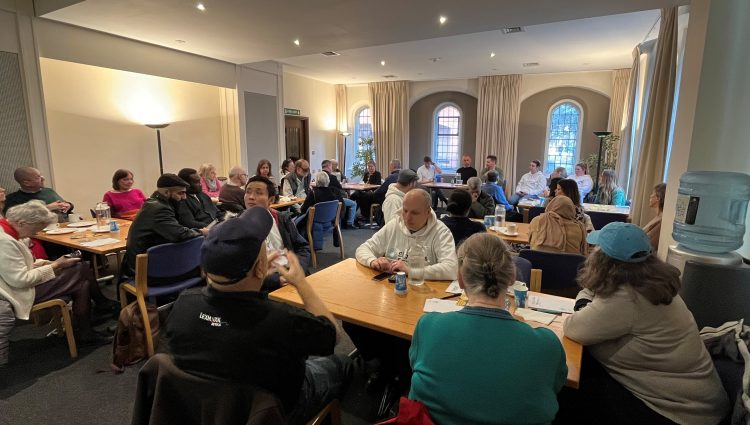 Attendees at London Sight Loss Councils' retail event. Image taken from the back of the room and shows several tables of attendees seated during the event.