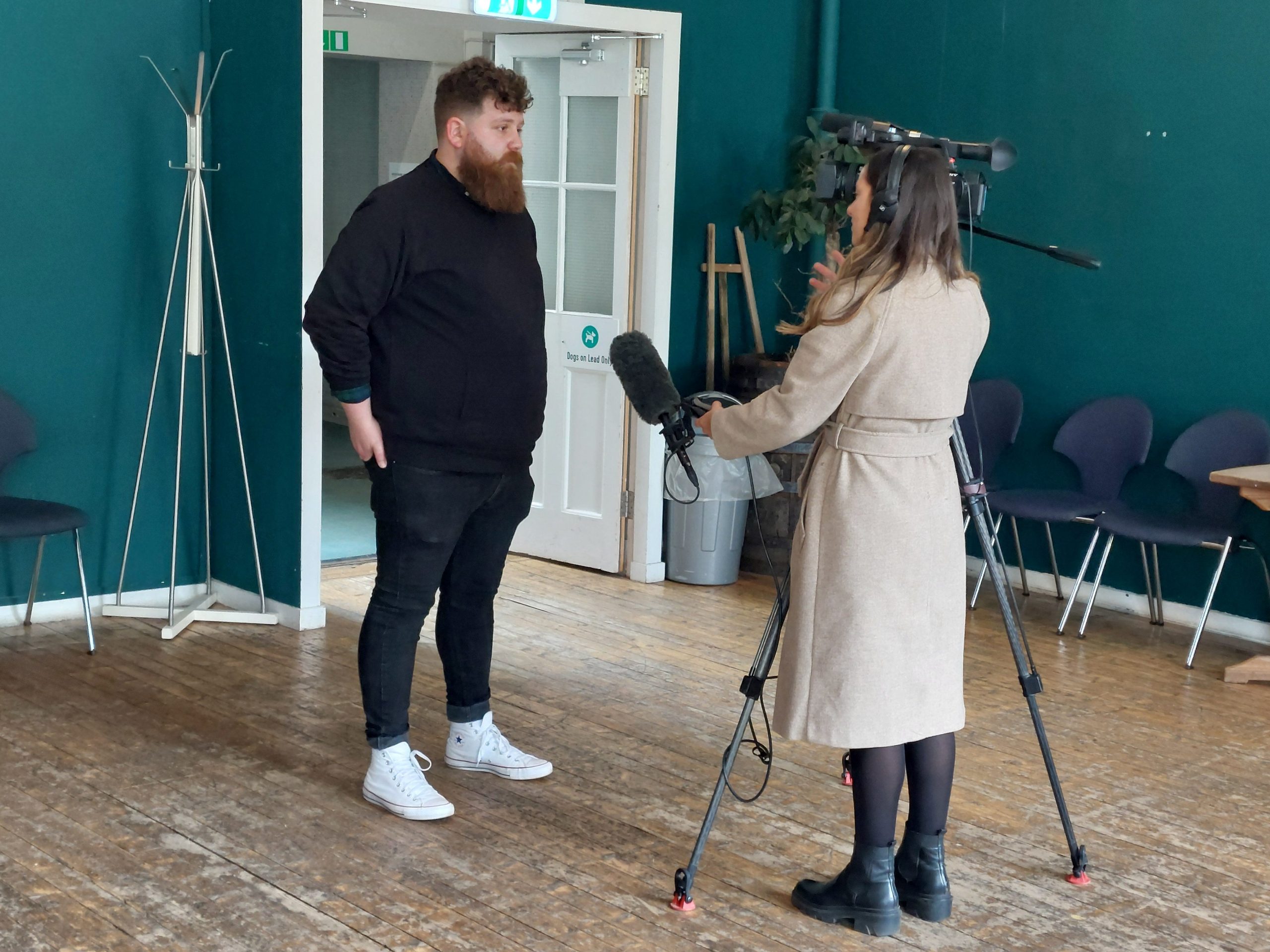 Callum Lancashire, Engagement Manager for Scotland, being i interviewed on camera by a female news anchor from STV.