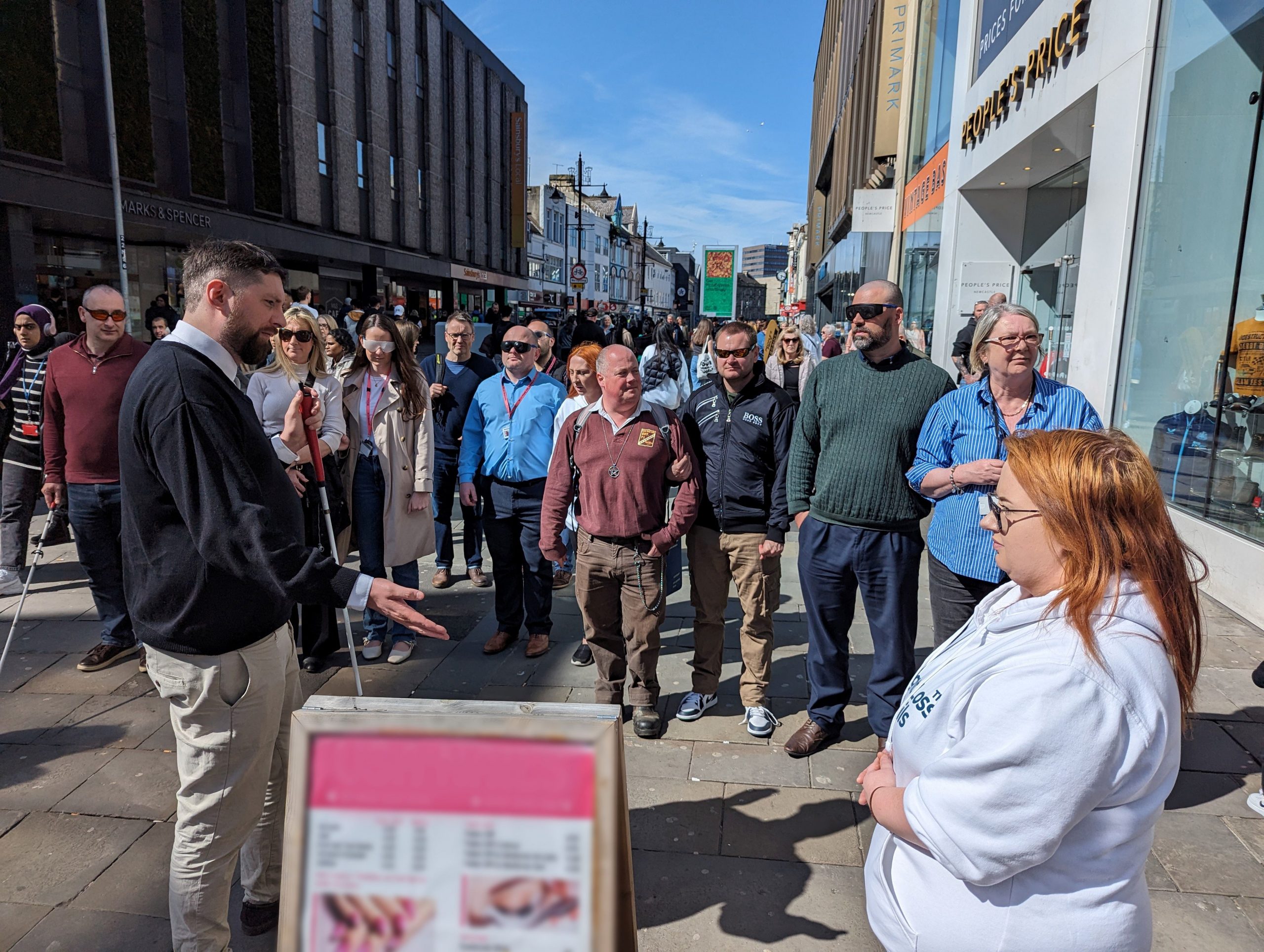 Jack, Engagement Manager for North East, is standing next to an advertising board, demonstrating why misplaced a-boards are hazardous.