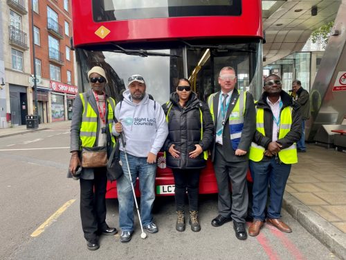 SLC volunteer, Steve Reed, in front of a bus with four drivers/ trainers