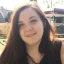 Samantha Leftwich headshot. Sam has long dark brown hair and is wearing a black top. She is smiling at the camera. 