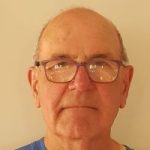 Peter Moody headshot. Peter is wearing a blue t-shirt and glasses and is facing the camera.